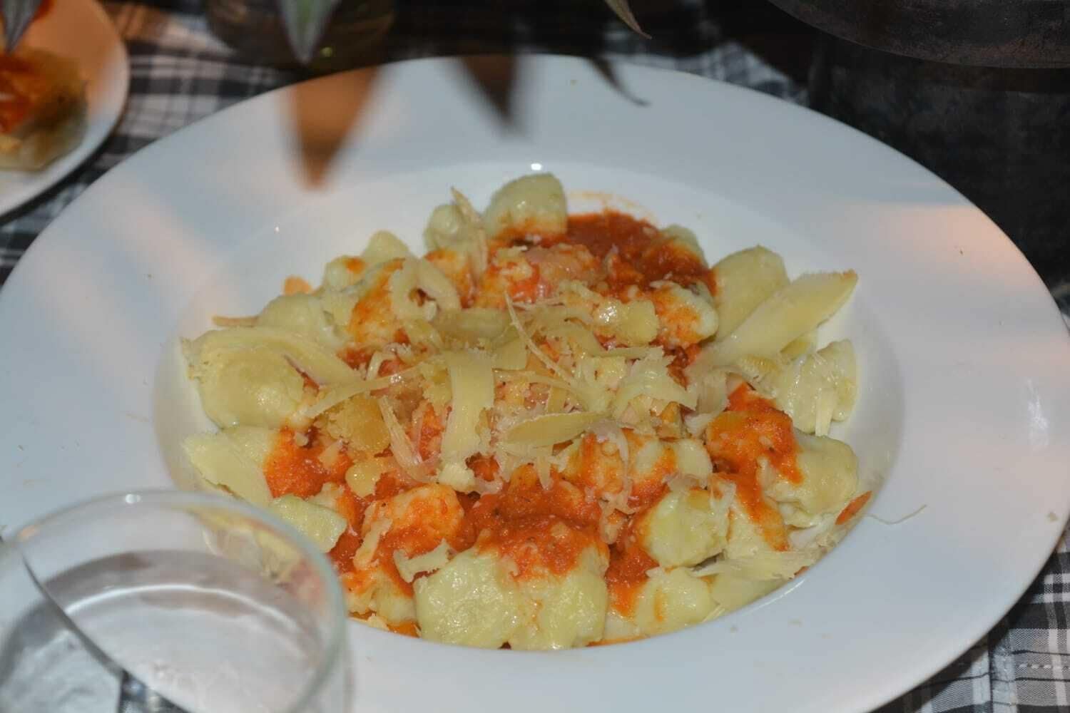 Um prato de massa com molho de tomate e queijo ralado.