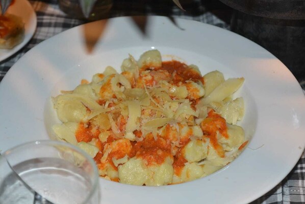 Un plato de pasta con salsa de tomate y queso rallado.