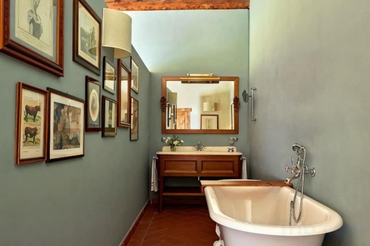 A bathroom with a bathtub, vanity, and wall-mounted mirror.