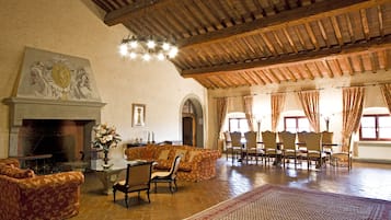 A spacious living room with a fireplace, comfortable seating, and a large rug.