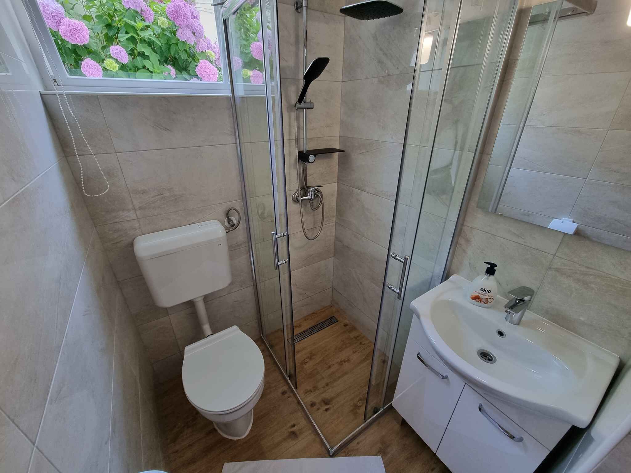Un baño moderno con inodoro, ducha y lavamanos.