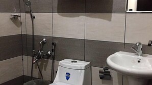 A bathroom with a toilet, bidet, and sink. - Pavithram Homestay (Devikolam)
