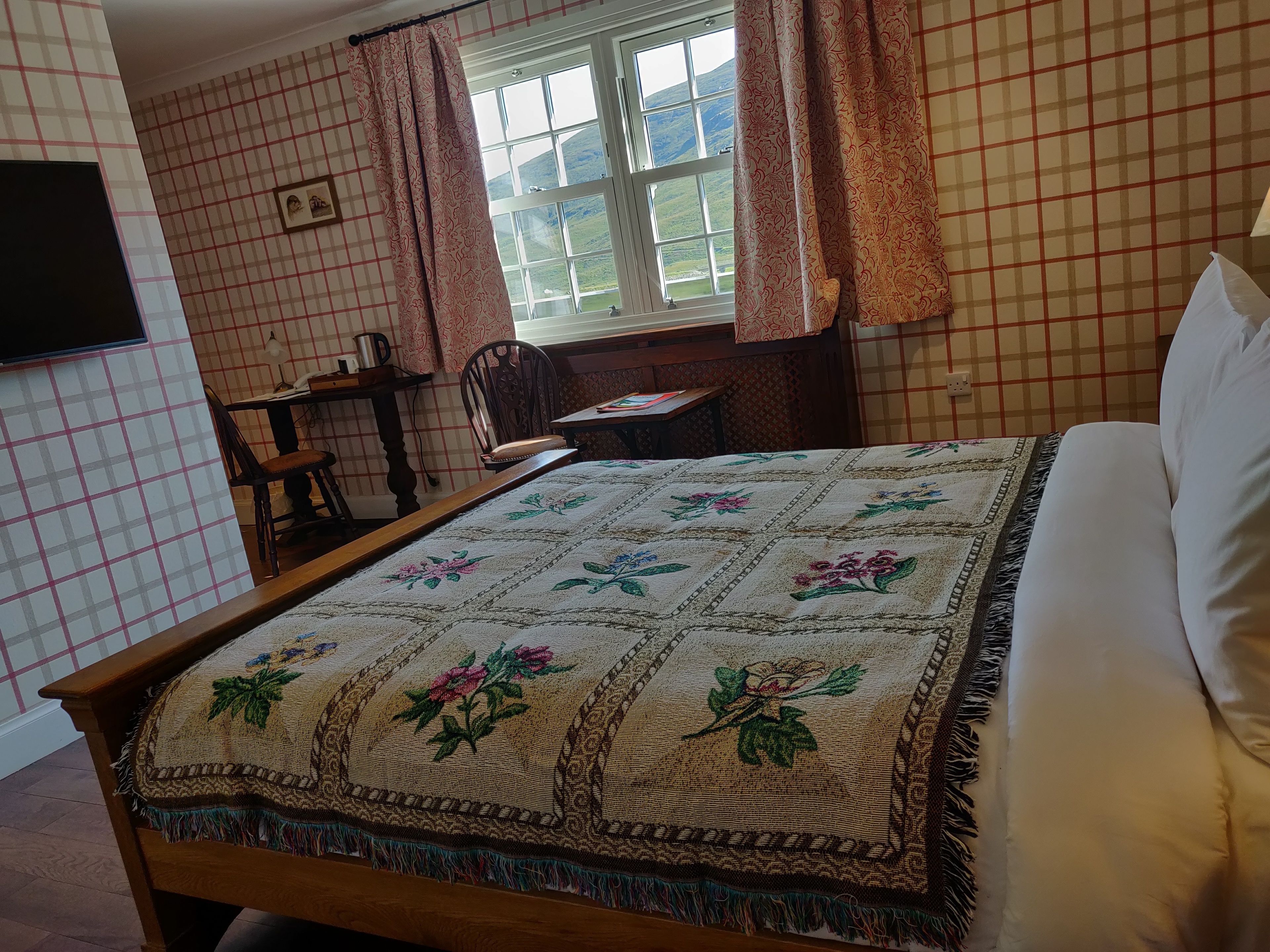 Une chambre à coucher avec un lit, un bureau, une chaise et une fenêtre avec des rideaux.