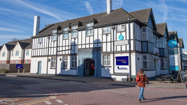 A traditional building with a sign for 'Redwings Lodge' and a 'Reception' sign. - Redwings Lodge Solihull (Solihull)