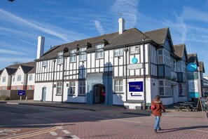 Un edificio tradicional con un letrero que dice 'Redwings Lodge' y un letrero que indica 'Recepción'.