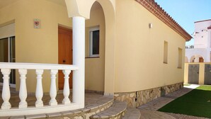 A building with a stone-paved entrance, a white balcony, and a door. - Villa with private pool for 7 people, 4000m from the beach, private pool (L'Ametlla de Mar)