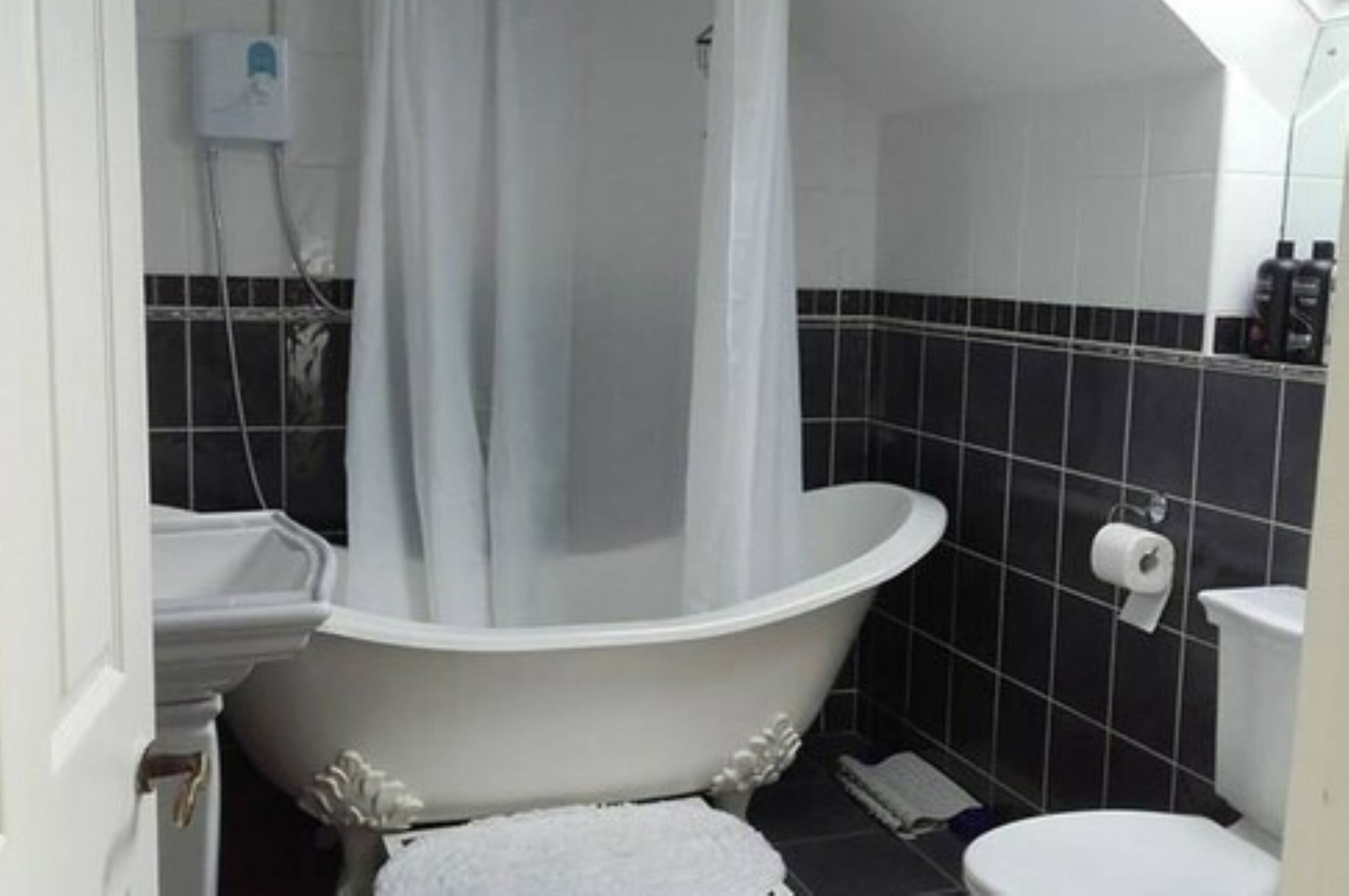 Ein Badezimmer mit einer weißen Badewanne, einer Toilette und einem Waschbecken.