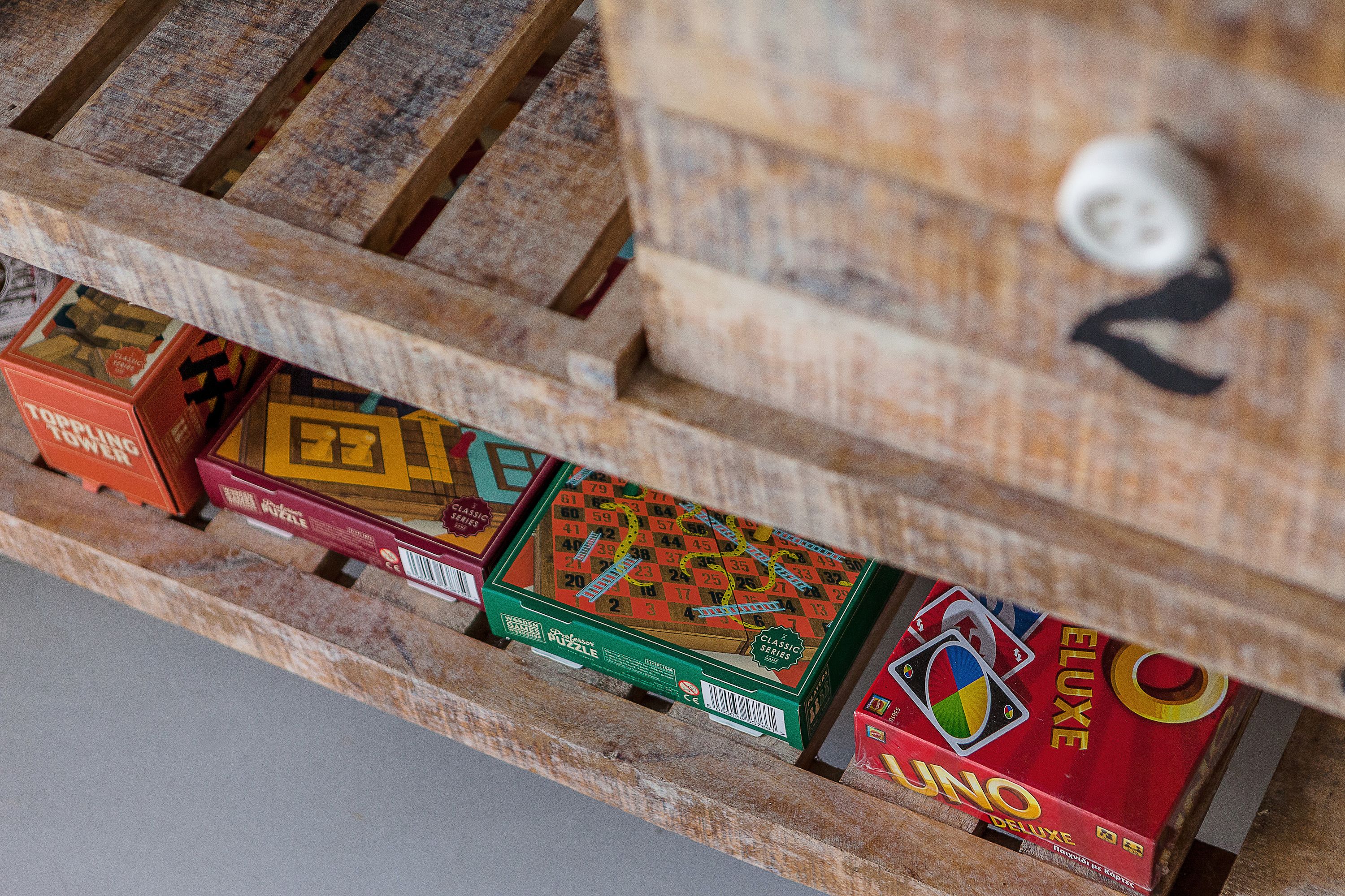 Un estante de madera con varios juegos de mesa.