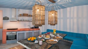 A modern kitchen with a built-in oven, a sink, and a dining area with a table set for a meal.
