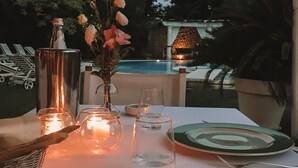 A table set for a meal outdoors with a pool in the background. - Relais Villabella (San Bonifacio)