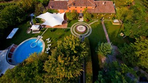 An aerial view of a property with a swimming pool, a large white tent, and a circular garden feature. - Relais Villabella (San Bonifacio)