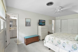 A bedroom with a bed, dresser, and a television.
