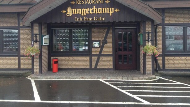 Un restaurante llamado 'Hungrkamp', con fachada de ladrillo y una entrada de color marrón oscuro.