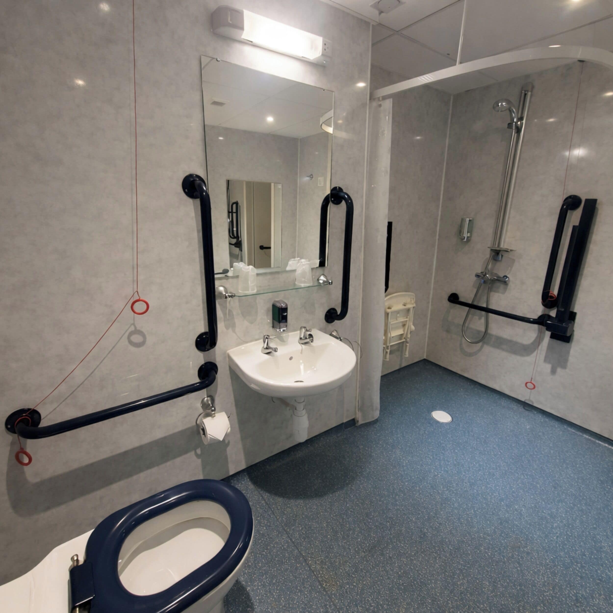 Un baño moderno con lavamanos, inodoro y ducha.