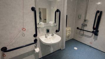 Un baño moderno con lavamanos, inodoro y ducha.