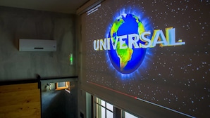 Proyección de la Tierra con la palabra 'UNIVERSAL' en una pared, indicando una ubicación relacionada con Universal Studios.