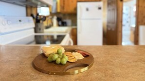 A kitchen counter with a cheese platter, grapes, and crackers. - Mountain Views | Fire Pit | little bear cabin (Island Park)