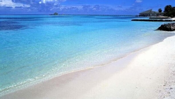 A beach with clear turquoise water, white sand, and a house on a small island in the distance. - August Hot Summer Special On The Beach!! 199nt. Disc for August ..Pet Friendly! (Destin)