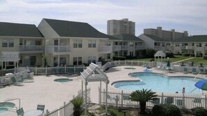 A hotel with a swimming pool, multiple balconies, and a fenced area. - August Hot Summer Special On The Beach!! 199nt. Disc for August ..Pet Friendly! (Destin)