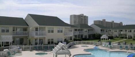 Et hotel med swimmingpool, flere balkoner og et afspærret område.
