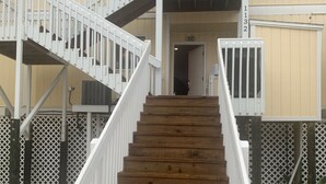 A wooden staircase leading to a building with a beige exterior and white railings. - August Hot Summer Special On The Beach!! 199nt. Disc for August ..Pet Friendly! (Destin)