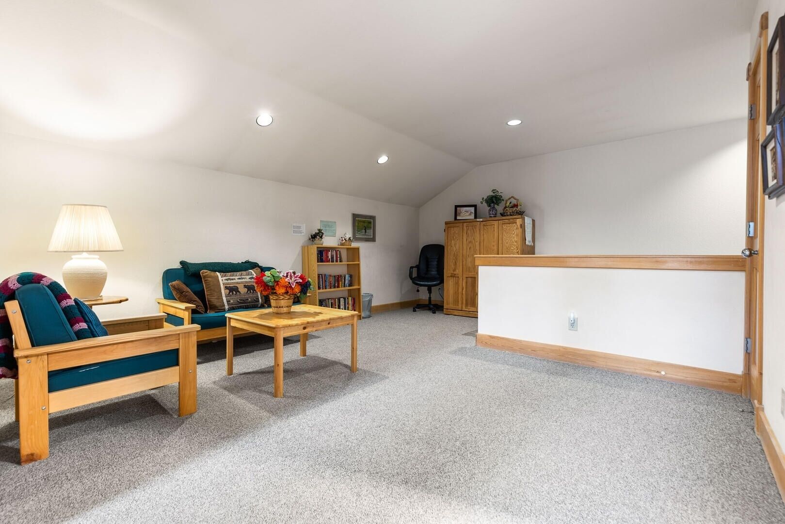 Un salon confortable avec un canapé, une table basse, une bibliothèque et un meuble en bois.