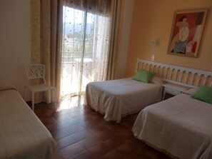 A room with two beds, a chair, and a painting on the wall. - Hotel Plaza Miami (Mont-roig del Camp)