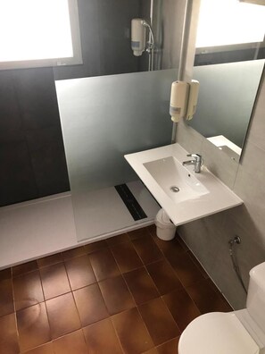 Une salle de bain moderne avec un lavabo blanc, un miroir et une douche.