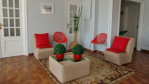 A living room with two striped sofas, red cushions, and a patterned rug.