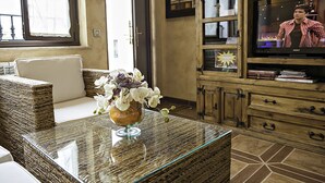 A living room with a glass coffee table, wicker furniture, a sofa, and a television on a wooden cabinet. - GÎte Antonio for 6 people in Salamanca, with swimming pool and Wi-Fi connection /OFFERS (Vitigudino)