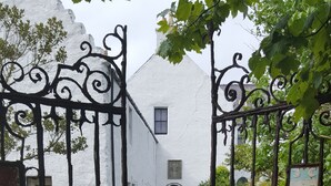 Un sendero de piedra que conduce a un edificio blanco con una puerta negra.