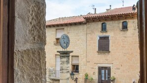 A stone building with a clock, windows, and balconies. - Hotel Villa de Cretas (Cretas)