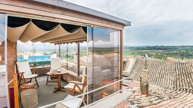 A balcony with a view of a valley, furnished with chairs and a table. - Hotel Villa de Cretas (Cretas)