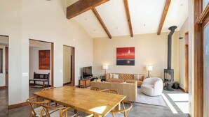 A spacious living area with a wooden dining table, comfortable seating, a sofa, and a fireplace. - Beautiful View by Hauserman Rentals (Tahoe City)