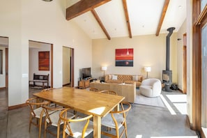 Un vaste espace de vie comprenant une table à manger en bois, des sièges confortables, un canapé et une cheminée.