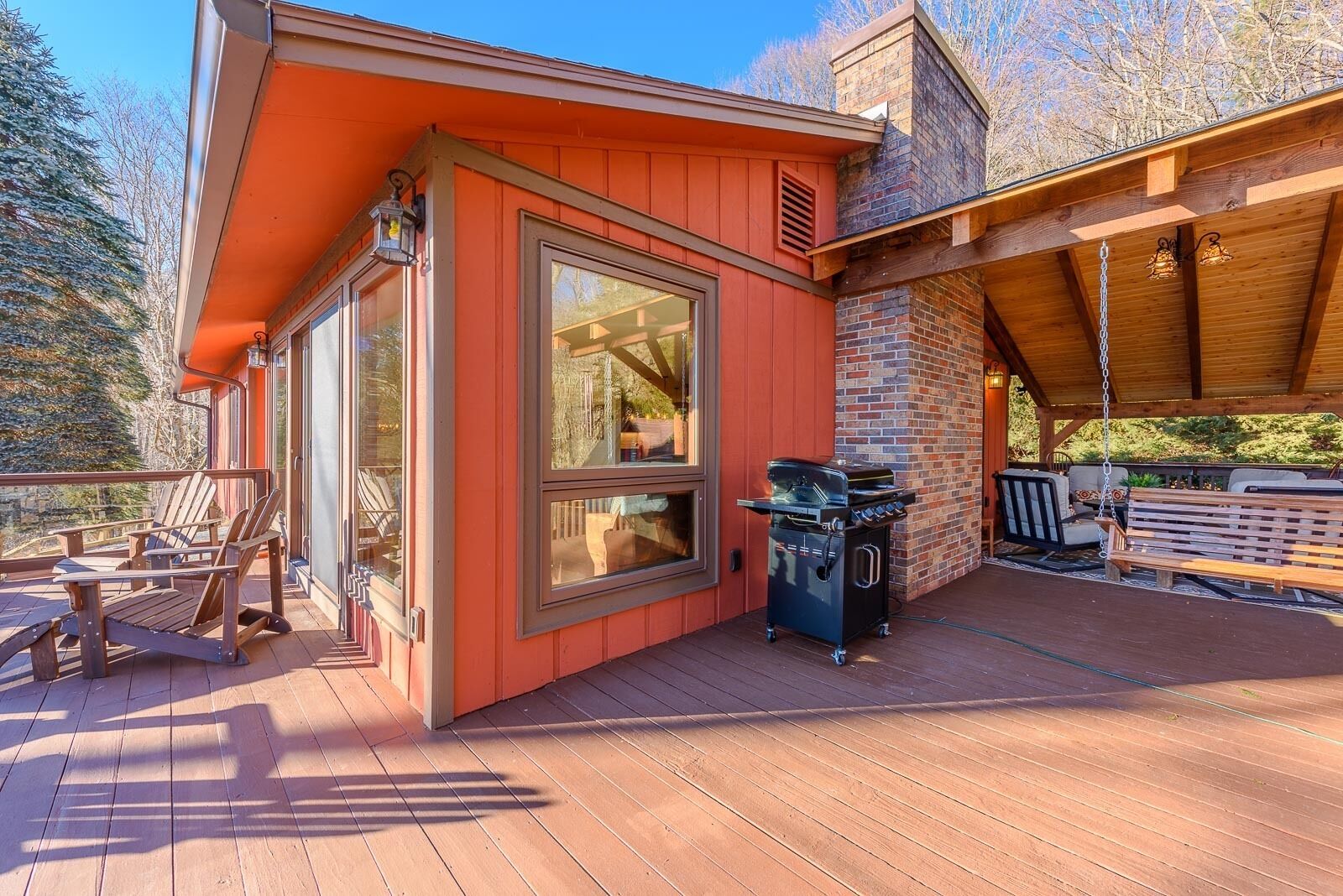 Une terrasse en bois avec un barbecue et des meubles d’extérieur.