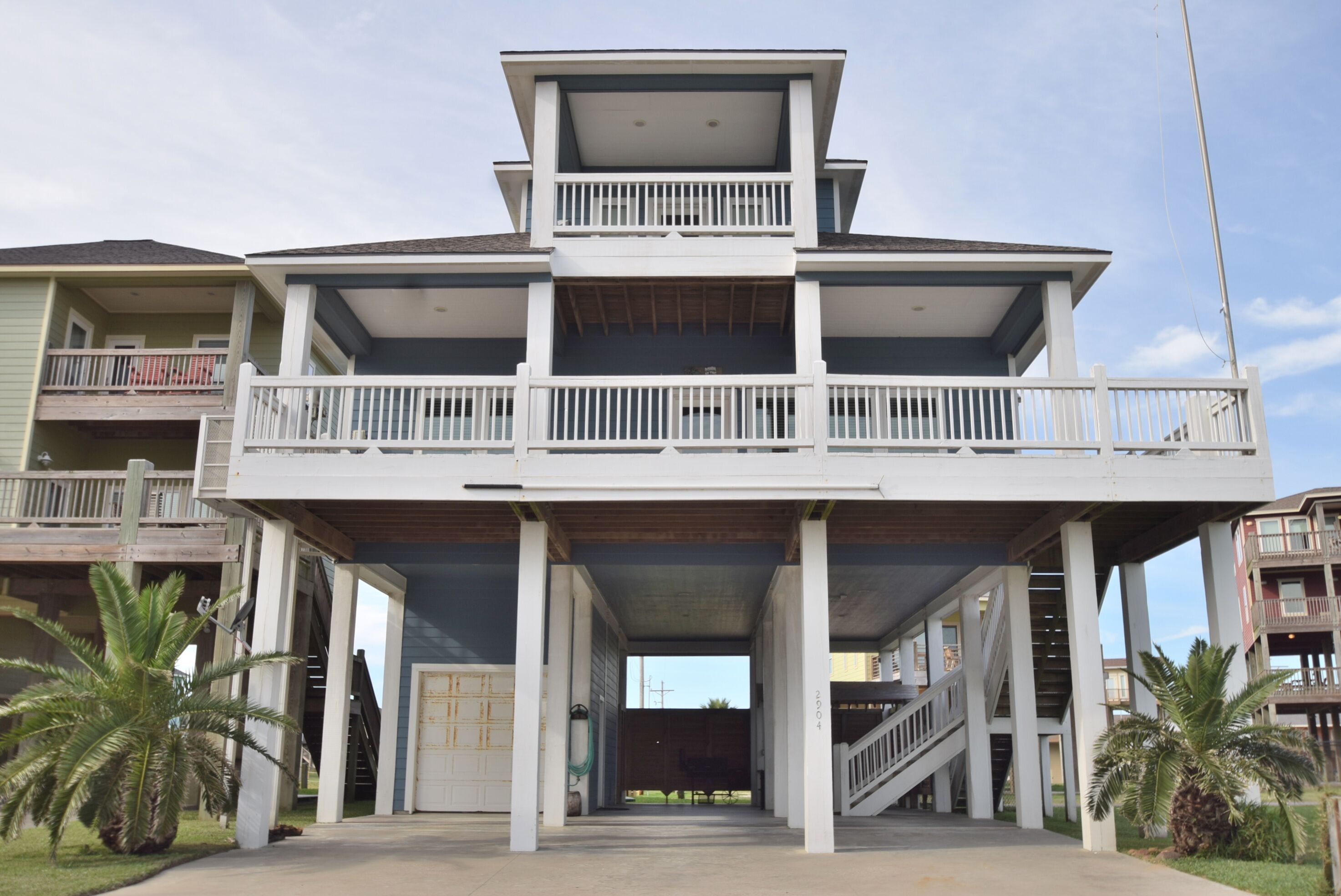 Un edificio de varios pisos con una escalera central abierta, balcones y un área de entrada cubierta.