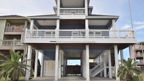 A multi-story building with a central open staircase, balconies, and a covered entrance area. - Luxury in Crystal Beach~ 4/3 ~ Beautiful Beach Views~Direct beach access (Crystal Beach)