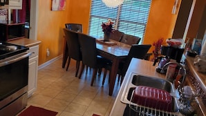 A kitchen with a dining table, chairs, a chandelier, and a sink. - HOME AWAY FROM HOME FOR THE MASTERS (Augusta)