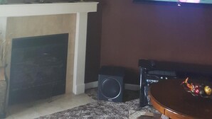 A living room with a fireplace, a television mounted on the wall, and a coffee table. - HOME AWAY FROM HOME FOR THE MASTERS (Augusta)