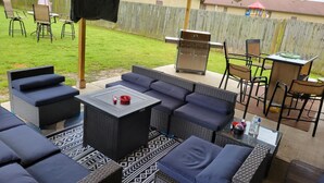 An outdoor patio with wicker furniture, a grill, and a covered area with a ceiling fan. - HOME AWAY FROM HOME FOR THE MASTERS (Augusta)