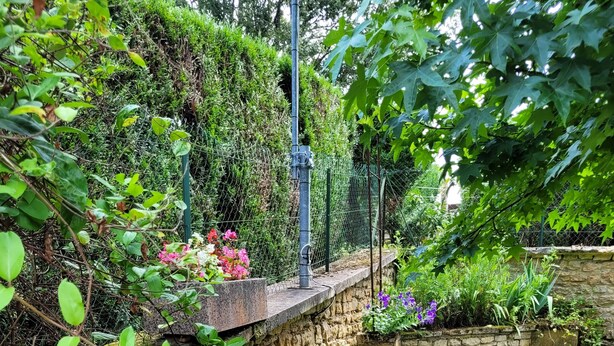 A stone retaining wall with a grassy area and a variety of plants and flowers. - Studio in Sarlat, for a couple in search of calm (Sarlat-La-Canéda)