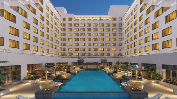 Un hôtel doté d’une piscine centrale, de nombreux balcons et d’une architecture moderne.