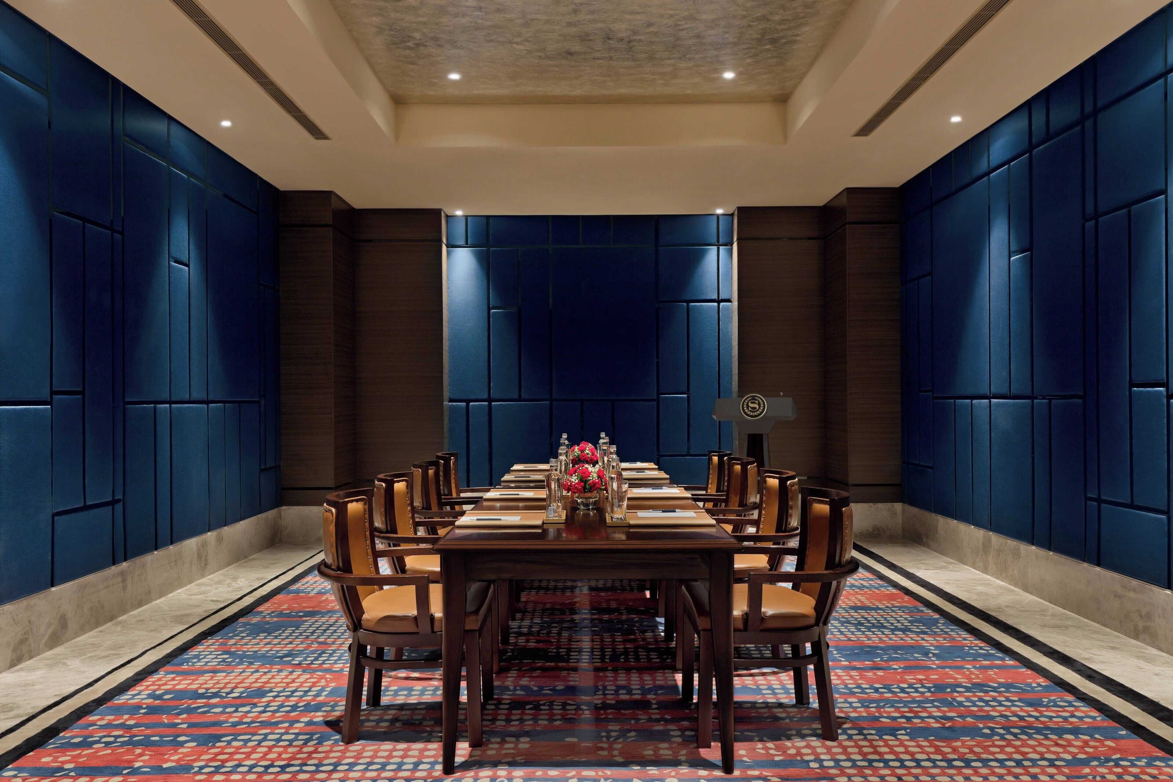 Een vergaderzaal met een lange tafel, stoelen en een decoratief middelpunt.