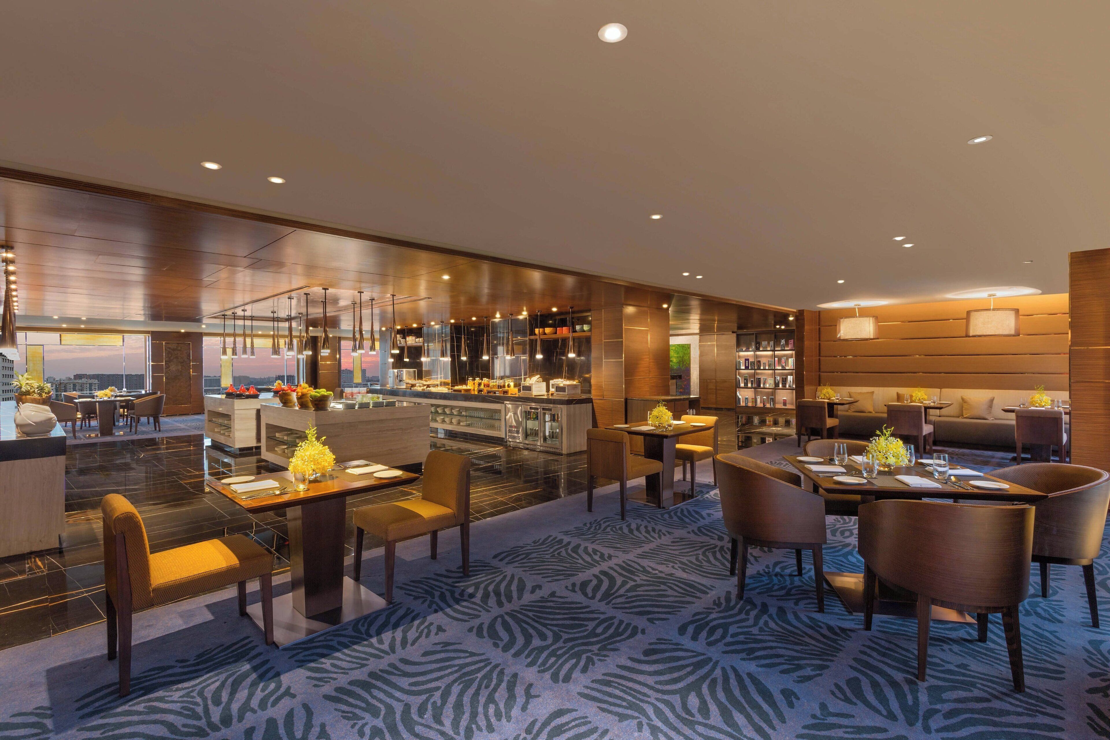 Een moderne hotelentree met een bar, een zithoek en uitzicht op de stad.