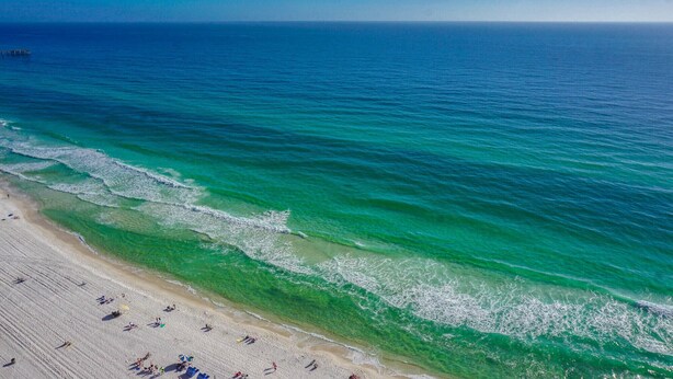 A beach with clear turquoise water and a sandy shore. - Beach Front Property in Panama City Beach Florida (Panama City Beach)