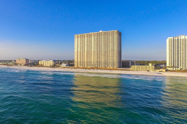 A high-rise hotel with a beach view, located near the shoreline.