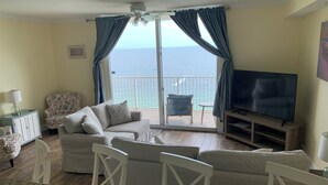 A living room with a sofa, TV, and a view of the sea. - Beach Front Property in Panama City Beach Florida (Panama City Beach)