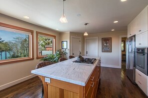 Una cucina moderna con un'isola grande, mobili in legno ed elettrodomestici in acciaio inossidabile.