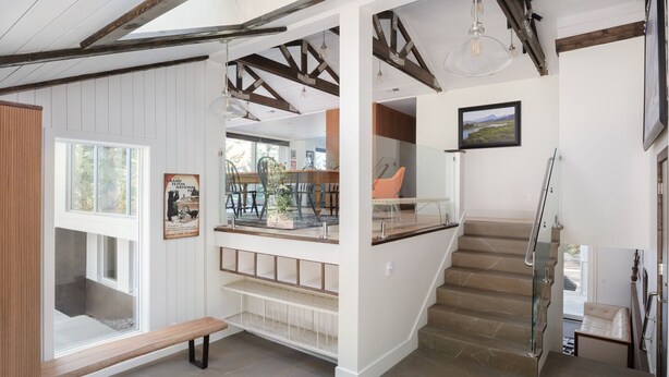Un intérieur moderne avec un escalier, un banc et un coin repas offrant une vue agréable.